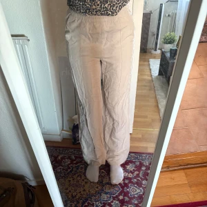 Linnebyxor - Säljer ett par beiga linnebyxor från H&M i storlek XS. Byxorna har resår i midjan. Passar mig i längden som är 177cm