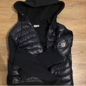 Svart cardigan  pufferjacka med huva från Moncl - Snygg svart cardigan  pufferjacka från Moncler med huva och dragkedja. Jackan kan man ha hela tiden och är jätte snygg säljer den pågrund av den har blivit liten på mig.