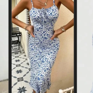 Blommig långklänning med snörning - Supersnygg långklänning med blått blommigt mönster. Klänningen har smala axelband och snörning vid bysten. I fint skick.