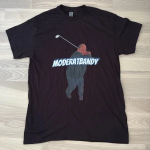 Moderatbandy - Tshirt - Säljer en custommade moderatbandy T-shirt, storlek S, den kommer i plastförbackning. Perfekt på spex eller golfbanan (helt ny). 