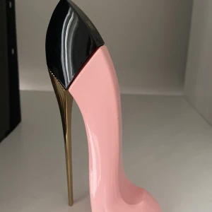 Good Girl Blush EdP från Carolina Herrera - Parfymflaska formad som en högklackad sko i glansig ljusrosa med svart topp och guldig stilettklack. Ikonisk design från Carolina Herrera, perfekt som statement på sminkbordet. Doften är feminin och modern, och flaskan är tillverkad i plast och metall.