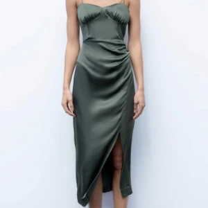 Mörkgrön satinklänning med slits - Säljer en elegant mörkgrön långklänning i satin med smala axelband och omlott-detalj framtill. Klänningen har en snygg slits och drapering vid höften. Använd och tvättad en gång! 💞💞