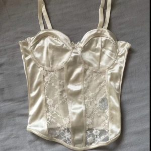 Vit spets topp  - En vit korsettopp från H&M Divided med spetsdetaljer framtill. Toppen har reglerbara axelband. Endast testad!
