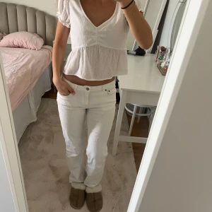 Vit blus med prickigt mönster - Säljer en söt vit blus med små prickar och v-ringning. Blusen har korta puffärmar. Perfekt för vår och sommar!