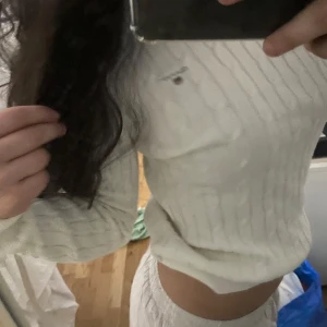 Vit ribbad croppad tröja från gant - Säljer en vit croppad tröja från  Gant med diskret logga på bröstet. Tröjan är ribbad och har lång ärm, perfekt för en stilren och enkel look. Passar till både jeans och kjol. St S -M misstänker ja😝  Och köpte för lite över 1000💗