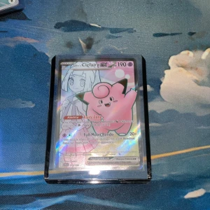 Pokémonkort: Lillie's Clefairy GX - Lillies clefairy kort som går för ungefär 200kr rå kortet har en 95% chans för en psa 10 rating som skulle ta upp kortets värde till 1000kr kortet har inga fel som man kan se på bilden och jag har även lagt den i en sleeve och en toploader så inget sker med den 
