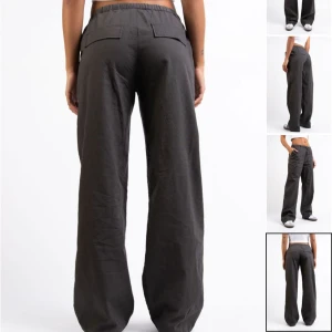 Low waist linnebyxor  - Snygga mörkgrå linnebyxor med avslappnad passform och raka, vida ben. Byxorna har resår och dragsko i midjan samt fickor bak. Strl M Short. 