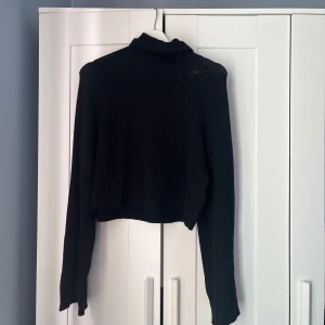 Svart stickad tröja - Svart stickad tröja med polokrage och utsvängda armar från bikbok, storlek XS, använd fåtal gånger