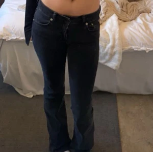 Svarta bootcut jeans - Svarta jeans med bootcut-passform och låg midja. Klassisk femficksmodell med knapp och dragkedja framtill. Perfekta för en avslappnad och trendig look.