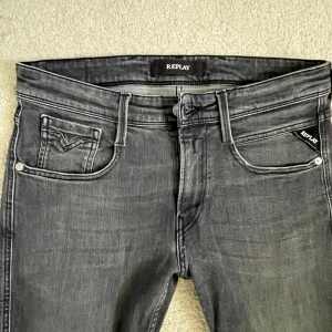 Replay grå jeansbyxor - Säljer ett par grå jeansbyxor från Replay med klassisk femficksdesign och smal passform. Nypris 1799 och mitt pris endast 449. Skick 8/10. Har inga tecken på slitningar men har använts en del. 