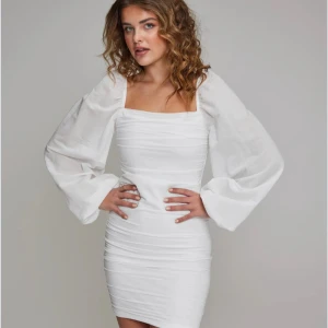 Vit kortklänning med puffärmar - Trendig vit kortklänning med fyrkantig ringning och långa puffärmar. Klänningen har figurnära passform och dragkedja i ryggen. Perfekt för dig som vill sticka ut med en stilren och modern look. (Ursprungligs pris 399 nu har de ändrat för tillfället till 159) 