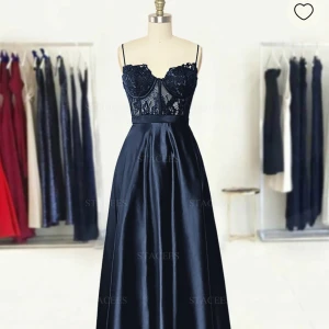 Mörkblå balklänning med spets från Stacees - oanvänd🫶🏻 Elegant mörkblå långklänning med smala axelband, spetsdetaljer upptill och markerad midja. Har mönstrad spets och kjolen är i glansigt satinliknande material. Perfekt för bal.🤍 skriv för mer bilder