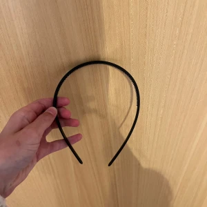 Svart diadem  - Enkelt svart diadem med små taggar på insidan för extra grepp. Passar perfekt för att hålla håret borta från ansiktet och ger en stilren look.