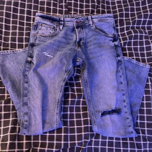 Blåa jeans  - Säljer ett par klassiska blåa jeans från Jack jones med slitningar . De är slimfit och är storlek 29/30. Skriv dm vid frågor!