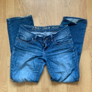Blå bootcut jeans från Esprit Denim - Skitsnygga lågmidjade blå jeans från Esprit Denim med bootcut-passform. Dom fick ett hål på högra benet som är igen-lappat på insidan. Skriv gärna för mer bilder, mått osv💗💗