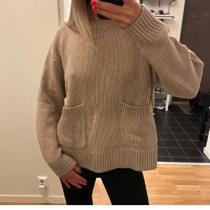 Beige stickad tröja med fickor - Mysig beige stickad hoodie med två stora fickor framtill och ribbade muddar. Perfekt för kyliga dagar och enkel att matcha med jeans eller leggings. från zara i strlk M