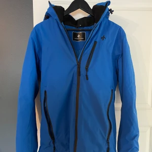 Blå skidjacka och skidbyxor från Cross Sportswear - Säljer ett skidset med blå jacka och byxor från Cross Sportswear. Det är använt en säsong och är i väldigt bra skick. Perfekt för alla vinteraktiviteter och i backen. Skidjackan är i storlek S och skidbyxorna är i storlek M
