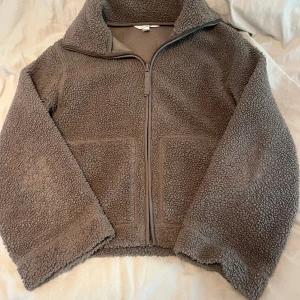 Brun teddyjacka från hm - Mysig brun teddyjacka med hög krage och dragkedja framtill. Storlek XS men passar mig med XS/S köptes i Japan för ett halvår sen och är knappt använd❤️