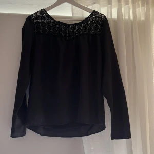 Svart blus med spets från Esmara - Säljer en svart blus från Esmara med vacker spets upptill och långa ärmar. Blusen har en rund halsringning och ett elegant fall. Perfekt för dig som gillar stilrena detaljer och spets. Den har innertyg. Jag säljer denna för 89 kr + frakt!