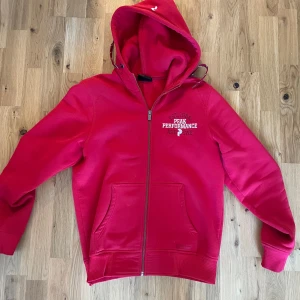 Peak Perfomance Åre Edition Zipup Hoodie - Säljer nu denna röda zipup hoodien då jag tappat intresse för den. OBS Finns lite småfläcker som knappt syns