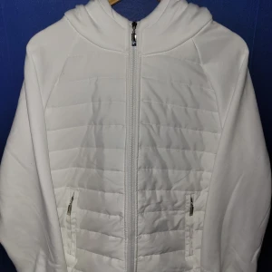 Vit pufferjacka med huva - Säljer en stilren vit cardigan hoddie med huva och dragkedja,  två fickor med dragkedja. Storlek M, mötes i haninge och fraktqs