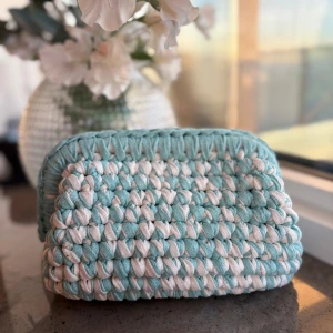 Handgjord virkad necessär i mintgrönt och vitt - Superfin virkad necessär i mintgrönt och vitt från Design by Bela. Väskan har en mjuk, fyrkantig form och är perfekt för att förvara smink eller småprylar. Tillverkad i tjockt, material som ger en mysig känsla och unik look. Kolla gärna in vår Instagram @design.by.bela för andra necessärer och väskor. Du kan även designa din egna väska utifrån din färg!