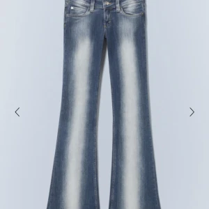 Blå bootcut jeans med utsvängda ben - Snygga blå jeans med bootcut och tydlig utsvängning nertill. Jeansen har en klassisk femficksmodell och ljusa slitningar längs benen för en cool look. Perfekta för dig som gillar retrostil och vill sticka ut.