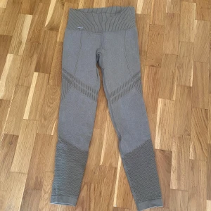 Grå/gröna träningstights från Aim'n - Nypris: 599kr.     Snygga grå/gröna träningstights från Aim'n med ribbad hög midja och mönstrade partier på benen. Tightsen har en tight, men också väldigt stretchig passform och är tillverkade i ett stretchigt syntetmaterial som passar perfekt till träning. Skulle säga att de passar S, M och L