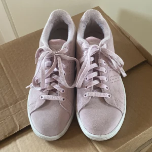 Ljusrosa sneakers från Adidas - Säljer ett par ljusrosa sneakers från Adidas då de tyvärr är för stora för mig. Skorna har snörning och vit platt sula. I fint skick!