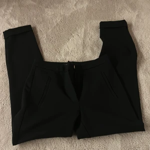 Svarta kostymbyxor från Lindex - Snygga svarta kostymbyxor från Lindex i modellen Iris. Byxorna har raka ben sitter tajt jag säljer då dom inte kommer till användning och priset kan diskuteras💗