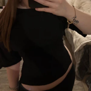 Svart topp med knyt i ryggen - Toppen är ifrån nelly och är endast använd ett fåtal gånger. Den har en snygg öppen rygg med knytband som ger en unik detalj. Perfekt för dig som vill ha en trendig och stilren look.