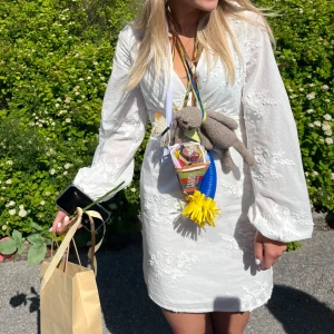 Vit blommig från Lindex - Superfin vit klänning från Lindex med broderade blommor och långa ärmar. Klänningen har v-ringning och lätt puffiga ärmar, perfektum till student eller skolavslutning, endast använd 1 gång🤍🤍