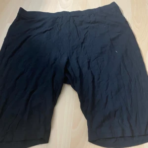 Svarta cykelshorts från Xint - Svarta cykelshorts från Xint i mjukt och stretchigt material. De har en enkel design utan synliga detaljer och är knälånga. Perfekta för träning eller som basplagg till vardags.