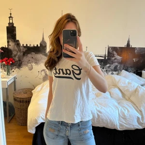 Vit t-shirt GANT - Vit t-shirt från Gant med stor svart logga framtill. Storlek 170 men känns som XS/S!! Väl använd med några fläckar (syns på sista bilden).