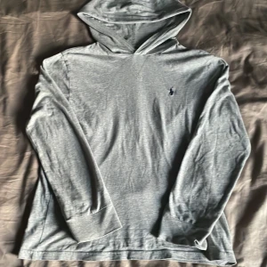 Ljusgrå hoodie från Polo Ralph Lauren - Säljer en stilren ljusgrå långarmad T-shirt från polo Ralph lauren bra skick strlk 150 och nypris 700 säljer för 250kr skriv vid funderingar pris går att diskutera