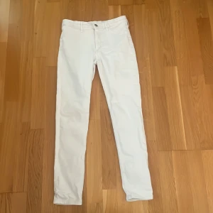 Vita skinny jeans i denim, strl 158 - Snygga vita skinny jeans i stretchig denim med klassisk femficksdesign och bälteshällor. Byxorna har smal passform och normal midja, perfekta för dig som gillar en clean och fräsch look. Stängs med knapp och dragkedja framtill.