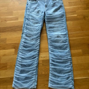 Unika ljusblå jeans från Weekday - Säljer ett par limited edition ljusblå jeans från Weekday med transparent meshdetaljer framtill som ger en riktigt cool och trendig look. Byxorna har raka ben och klassisk femficksmodell. 