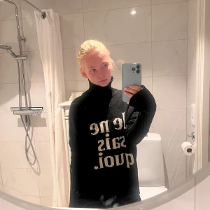 Svart polotröja Zadig & Voltaire - Svart stickad polotröja från Zadig & Voltaire med vit text 'Je ne sais quoi' framtill. Oversized fit med långa ärmar och tumhål i muddarna. Perfekt för dig som gillar statement-plagg och fransk vibe. Nypris 3599kr