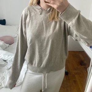 Beige hoodie  - Beige stickad hoodie från Gina Tricot med stora och små stjärnor ton-i-ton på axel och rygg. Tröjan har huva, långa ärmar och bred mudd nertill. Perfekt för chill dagar och enkel att matcha med allt.