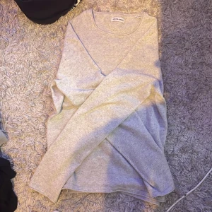 Ljusgrå stickad tröja Jack & Jones - En stilren ljusgrå stickad tröja från Jack & Jones i storlek XS. Tröjan har rund halsringning och långa ärmar, perfekt för lager-på-lager. Enkel och clean design som funkar till jeans eller chinos. Köpt för 450kr