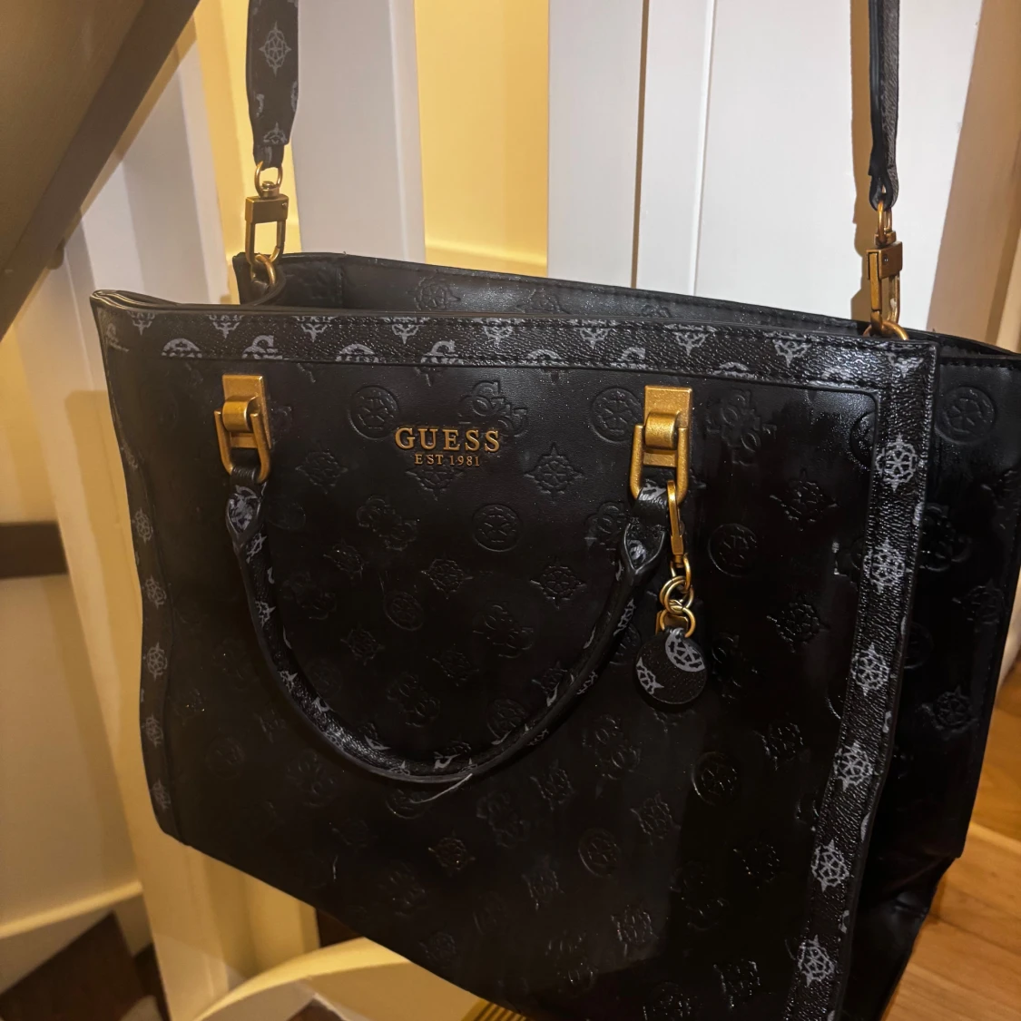 Svart handväska från Guess med mönster