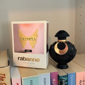 Olympéa Absolu Parfym från Rabanne - Säljer en Olympéa Absolu Parfum Intense från Rabanne. Flaskan är svart med guldiga detaljer och har en unik, rund form med elegant lock. Kommer i originalkartong med rosa och guld design. En lyxig och intensiv doft för dig som vill sticka ut. Aldrig använd 
