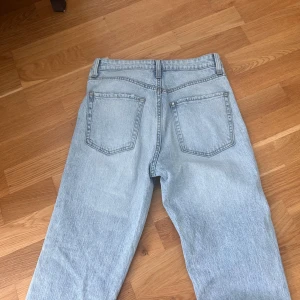 Ljusblå raka jeans - Säljer ett par ljusblå jeans med klassisk femficksdesign och raka ben. Jeansen har en avslappnad passform och är tillverkade i mjukt denimtyg. Perfekta för en chill och stilren look.