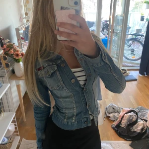 Blå jeansjacka  - Snygg blå jeansjacka med klassisk krage, bröstfickor, snygg urtvättad, och silverknappar 