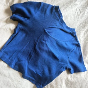 Blå ribbad topp med cut out-detalj - Säljer en blå ribbad topp med korta ärmar och en snygg cut out-detalj vid halsen. 💙