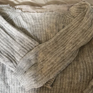 Grå ribbstickad tröja - Säljer en chunky grå ribbstickad tröja med lång ärm. Tröjan har breda ribbor och en klassisk rund halsringning. Perfekt för lager-på-lager och chill dagar. Passar dig som gillar en enkel men ändå snygg look. Har klippt den själv men ser ändå bra ut 