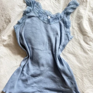 Ljusblå ribbad linnetopp med spets - Supersöt ljusblå linnetopp med ribbad struktur och breda axelband i spets. 🩵🦋