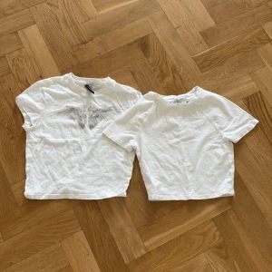2 vita t-shirts från H&M Divided XS - Två vita t-shirts från H&M Divided i storlek XS. Ena t-shirten är basic och clean, den andra har tryck med vingar och texten 'The Eclipse of the Heart' framtill. Båda har rund hals och korta ärmar, tillverkade i mjuk bomull.