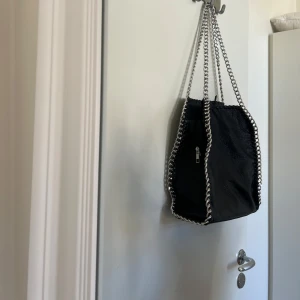 Svart axelväska från Tiamo - Svart skinnväska från Tiamo med silvriga detaljer 