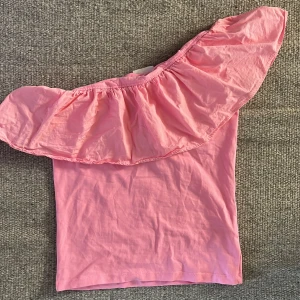 Rosa offshoulder topp med volang - Söt rosa offshoulder topp med med volang. Nästan aldrig använd så den är som i nytt skick.